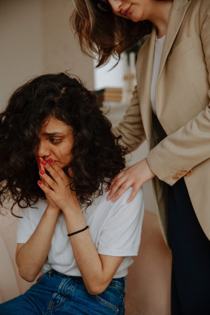 A young woman receiving comforting support in a counseling session.