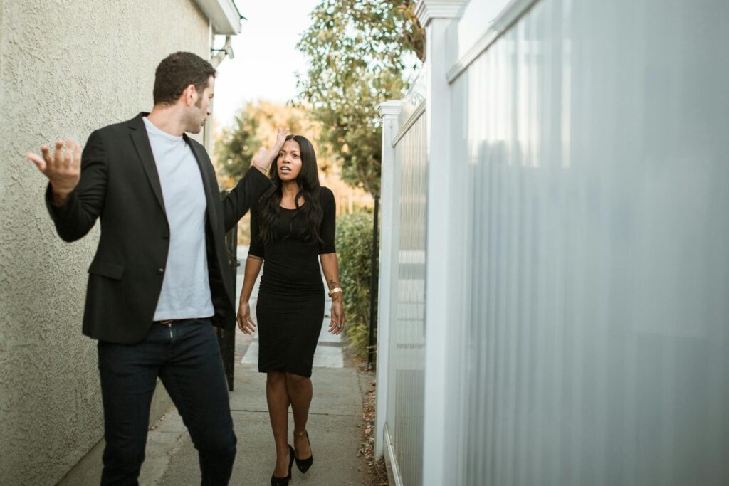 A couple engaged in a heated discussion in an alley, showing tension and misunderstanding.