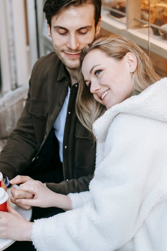 High angle of happy young couple in casual wear spending romantic date in cafe